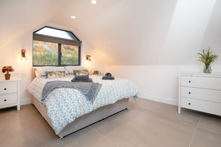 King size divan bed (which can convert to two twin beds) and two white chests of drawers in a modern bedroom with grey tiled floor
