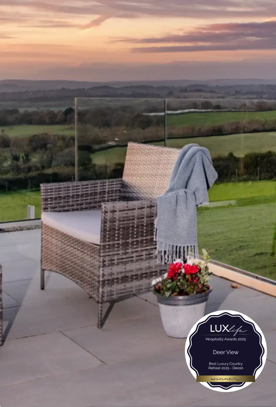 Modern garden chair on patio terrace overlooking countryside at dusk