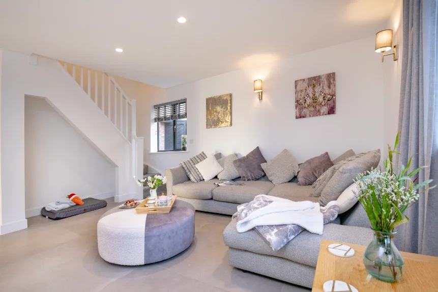 Large corner sofa in modern pale grey decor living room with stairs to first floor